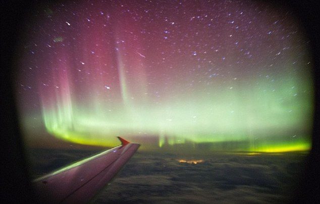 A traveller on a flight over the UK snaps a gorgeous photo of the Aurora Borealis out of a plane window.