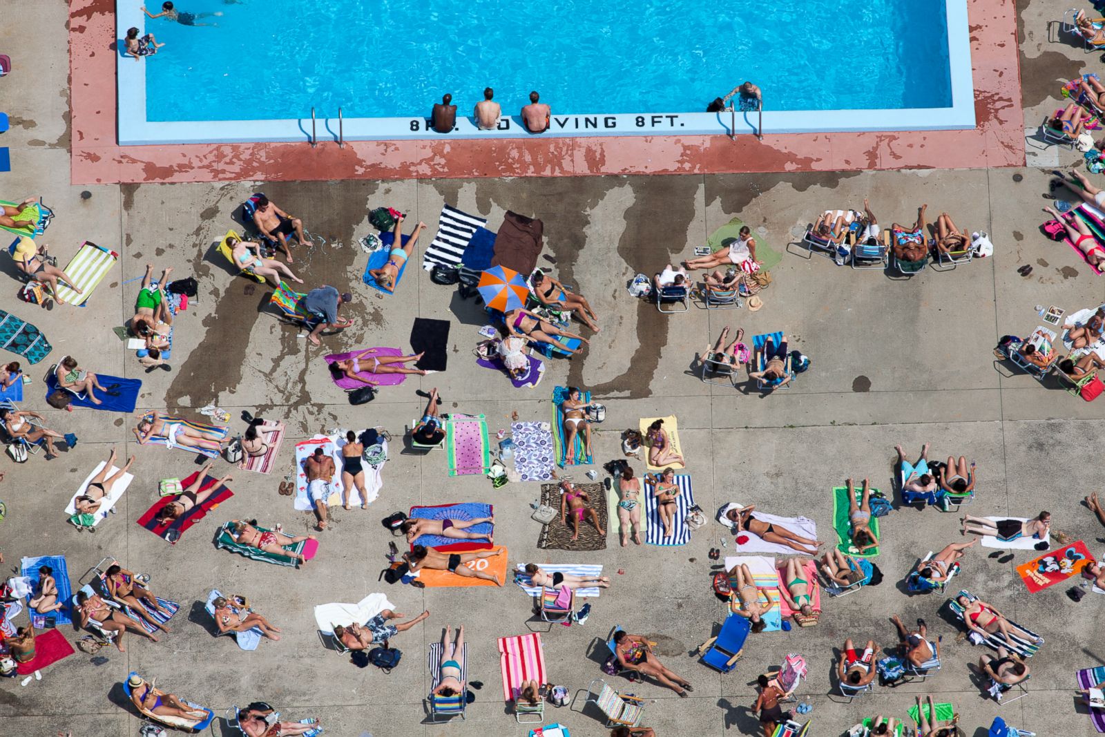 People tanning poolside in Cambridge, Massachusetts