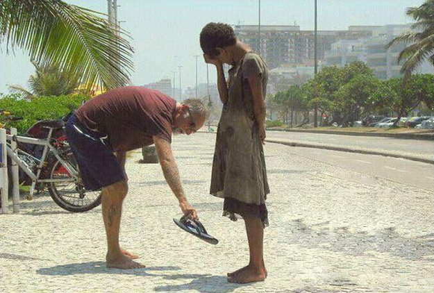 A man giving his shoes to a homeless girl in Rio de Janeiro.