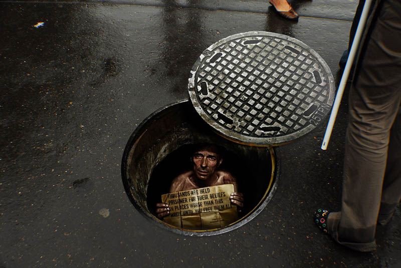 sidewalk-sticker-looks-like-a-person-is-inside-a-manhole