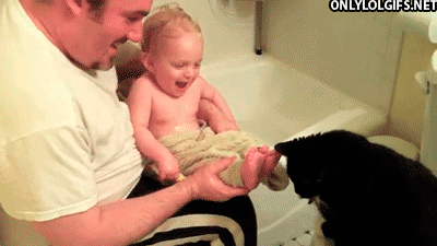 Baby laughing at a cat licking his feet